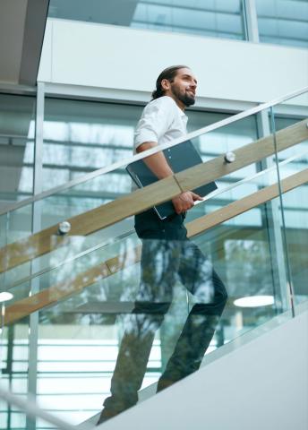 Person climbing stairs in large office building