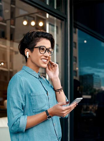 woman with earbuds listening to a phone call
